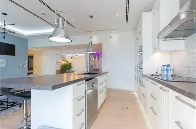 a kitchen with white cabinets and stainless steel appliances at AWS Holiday Homes - Spectacular Sea Views in Dubai