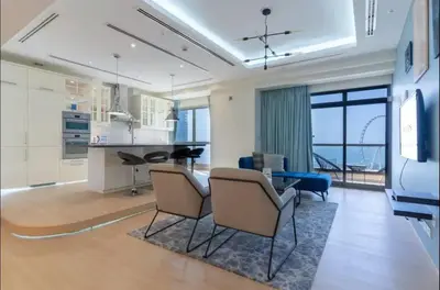 a kitchen and living room with a table and chairs at AWS Holiday Homes - Spectacular Sea Views in Dubai