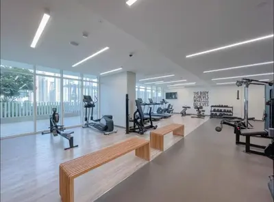 a gym with benches and exercise equipment in a room at AWS Holiday Homes - Memories by the Beach in Dubai