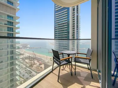 a balcony with two chairs and a table and a view of the ocean at Silkhaus 1BDR with Beach Access in Marina Vista in Dubai