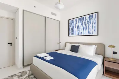 a bedroom with a large bed with a blue blanket at Silkhaus 1BDR with Beach Access in Marina Vista in Dubai