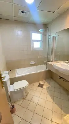 a bathroom with a toilet and a tub and a sink at Furnished Apartment in Silicon Oasis on Prime Location in Dubai