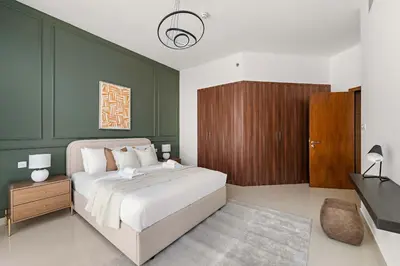 a bedroom with a bed and a green wall at Silkhaus Modern Studio in Reef Residence at JVC in Dubai