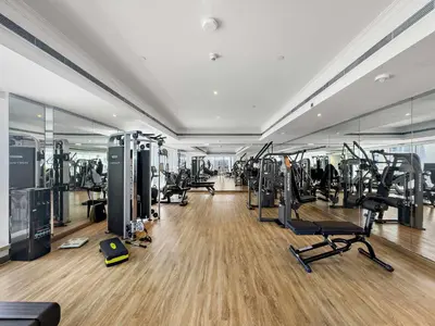 a gym with lots of treadmills and cardio equipment at Silkhaus Modern Studio in Reef Residence at JVC in Dubai