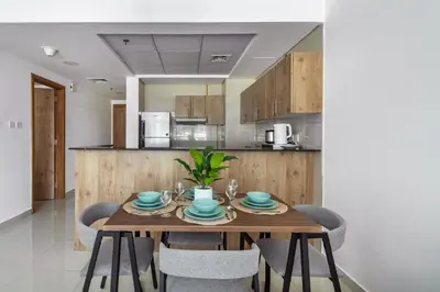 a dining room with a wooden table and chairs at ShoresInn - Artistic Retreat in Dubai Marina in Dubai