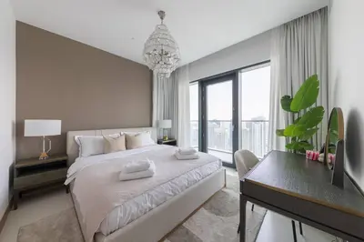 a white bedroom with a large bed and a desk at Vida Dubai Marina Residences in Dubai