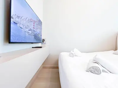 a bedroom with a flat screen tv on a wall at Cozy Studio with Balcony & Stunning Views in Dubai