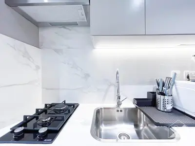 a kitchen with a sink and a stove at Cozy Studio with Balcony & Stunning Views in Dubai