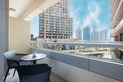 a balcony with a table and chairs and a view of a city at JuliusHomes - Studio in Bay Square, Business Bay Dubai in Dubai