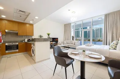 a kitchen and living room with a couch and a table at JuliusHomes - Studio in Bay Square, Business Bay Dubai in Dubai