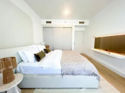 a white bedroom with a bed and a television at Stunning 2BR In Dubai Marina With Amazing views in Dubai