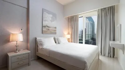 a bedroom with a large bed and a large window at Luxury 2BR apartment with Burj View GYM & Pool in Dubai