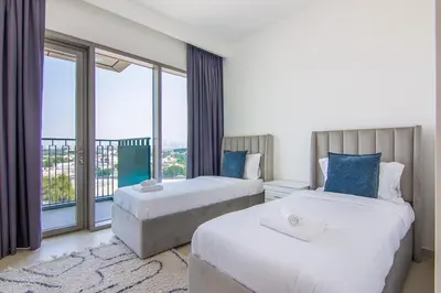 two beds in a room with a large window at Luxurious 2BR in Downtown Views II, Zaabeel Second in Dubai