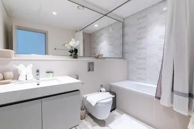 a white bathroom with a sink and a toilet at Luxury Living with Private Beach in Dubai