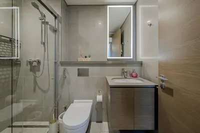a bathroom with a toilet and a sink and a shower at Stylish 1 BDR apartment in Sobha Waves in Dubai