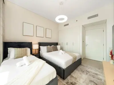 two beds in a bedroom with white walls at Chic 4 Bedroom Apartment I Burj Khalifa & Fountain Views I Direct Access to Dubai Mall I Free Gym, Pool, Parking Wi-Fi and PS5 I by Skyline Serenity in Dubai