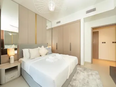 a bedroom with a large white bed and a table at Skyline 2 Bedroom Apartment I Burj Khalifa & Fountain Views I Free Gym, Pool, Parking, Wi-Fi and PS5 in Dubai