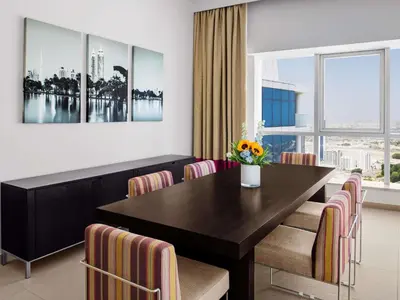 a dining room with a table and chairs at Adagio Premium Dubai Al Barsha in Dubai