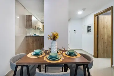 a dining room with a wooden table and chairs at ShoresInn - Splendid 1BR in Dubai Marina in Dubai