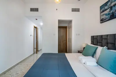 a bedroom with a large white bed with blue pillows at ShoresInn - Splendid 1BR in Dubai Marina in Dubai