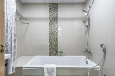 a white bathroom with a tub and a shower at ShoresInn - Splendid 1BR in Dubai Marina in Dubai