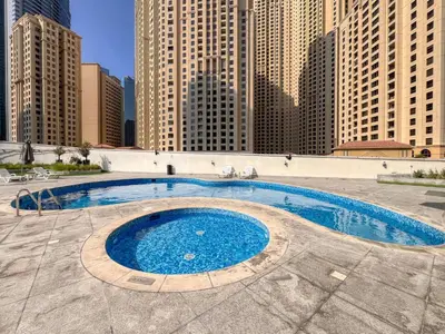 a large swimming pool in a city with tall buildings at ShoresInn - Splendid 1BR in Dubai Marina in Dubai