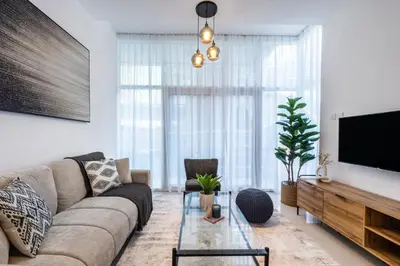 a living room with a couch and a tv at ShoresInn - Splendid 1BR in Dubai Marina in Dubai