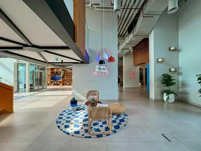 a lobby with a chair and a table and a light at Colorful1BR Apartment in Dubai Hills Next to Mall in Dubai