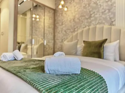 a bed with two towels sitting on top of it at Bright Studio in Azizi Riviera Perfect Getaway in Dubai