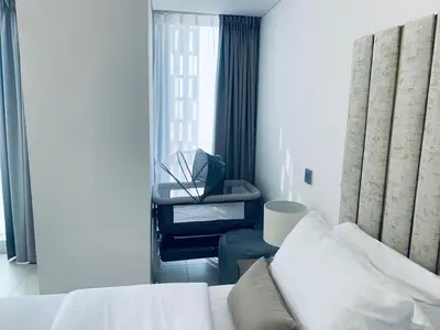 a bedroom with a white bed and a desk at Iconic Sea View Marina - LUX NEW in Dubai