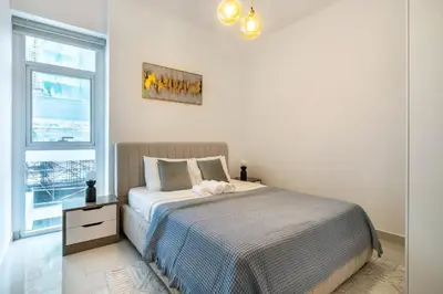 a bedroom with a bed and a window at ShoresInn - Elite 1BR in Dubai Marina in Dubai