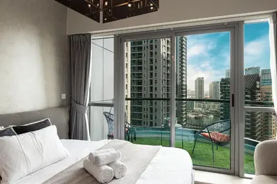 a bedroom with a bed and a large window at 2BR Steps from JBR Beach in Dubai