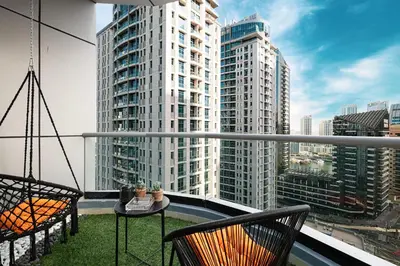 a balcony with two chairs and a table and some buildings at 2BR Steps from JBR Beach in Dubai