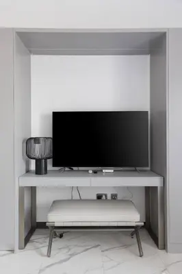 a flat screen tv on a shelf in a room at Brand New Studio 15 mins drive from Business Bay in Dubai