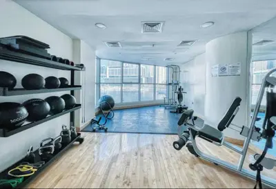 a gym with treadmills and weights in a room at FIRST CLASS 3BR Stylish Sanctuary in Dubai