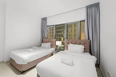 two beds in a room with a large window at FIRST CLASS 3BR Stylish Sanctuary in Dubai