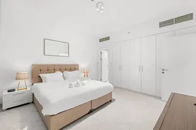 a white bedroom with a large bed and white walls at FIRST CLASS 3BR Stylish Sanctuary in Dubai