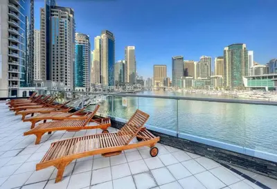 a row of wooden benches on a balcony overlooking a city at FIRST CLASS 3BR Stylish Sanctuary in Dubai