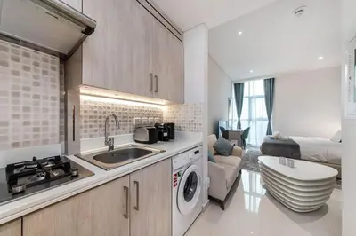 a kitchen with a sink and a washing machine at Cozy studio in Seven Palm in Dubai