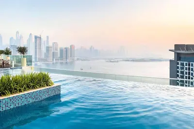 a swimming pool on top of a building with a city at Cozy studio in Seven Palm in Dubai