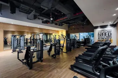 a gym with several rows of treadmills and machines at Cozy studio in Seven Palm in Dubai