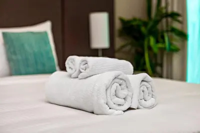 a pile of towels sitting on top of a bed at Lovely 1BR in Seven Palm in Dubai