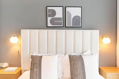 a bedroom with a white bed with two lamps at Central 1BR in Marina with Private Terrace & Pool in Dubai