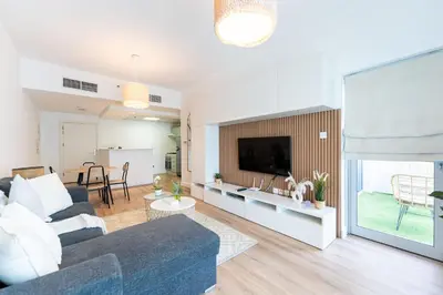 a living room with a couch and a tv at Central 1BR in Marina with Private Terrace & Pool in Dubai