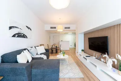 a living room with a couch and a flat screen tv at Central 1BR in Marina with Private Terrace & Pool in Dubai