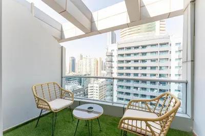 a balcony with two chairs and a table at Central 1BR in Marina with Private Terrace & Pool in Dubai