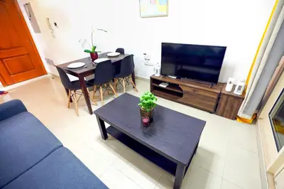 a living room with a couch and a table and a tv at Superb 1Bed Marina View pool JBR Beach Parking in Dubai