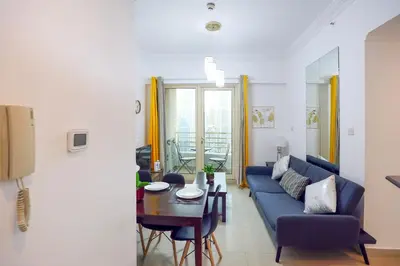 a living room with a blue couch and a table at Superb 1Bed Marina View pool JBR Beach Parking in Dubai