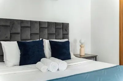 a bed with blue and white pillows at ShoresInn - Magnificent 1BR in Dubai Marina in Dubai