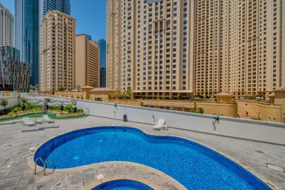a swimming pool on top of a building with tall buildings at ShoresInn - Magnificent 1BR in Dubai Marina in Dubai